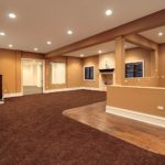 A large room with brown carpet and wood floors.